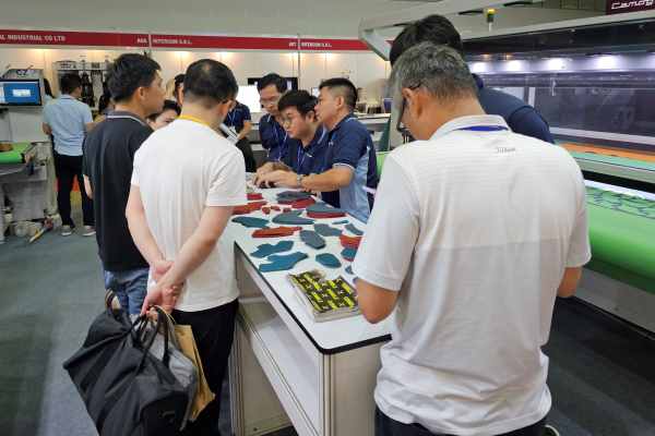 Buyer examining latest cutting technologies in footwear industry Buyer examining latest cutting technologies in footwear industry